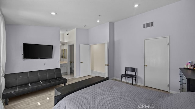 bedroom featuring wood finished floors, visible vents, baseboards, recessed lighting, and ensuite bathroom