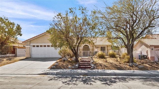 view of front of home with fence, driveway, an attached garage, stucco siding, and a tile roof