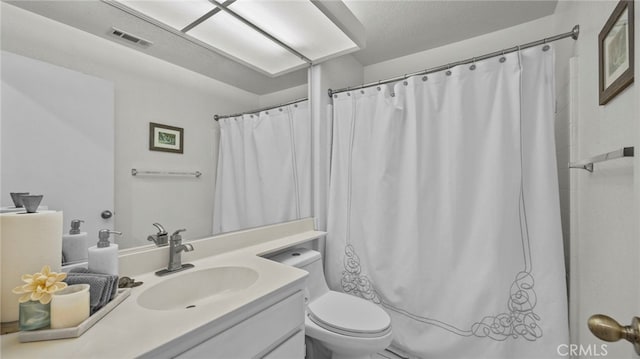 full bath featuring vanity, toilet, and visible vents