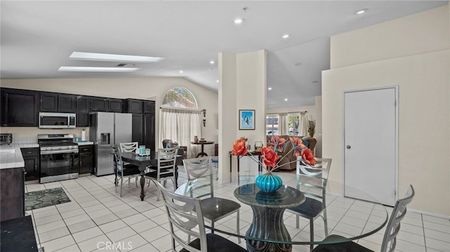 dining room with light tile patterned flooring, recessed lighting, and lofted ceiling with skylight