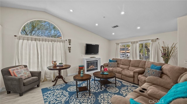 living area featuring a glass covered fireplace, visible vents, light wood-style flooring, and recessed lighting