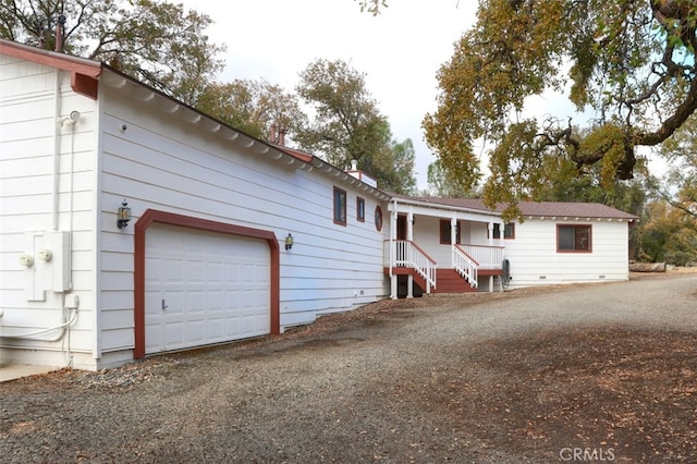 ranch-style home featuring a garage, driveway, and covered porch