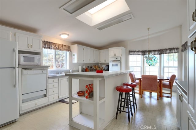 kitchen with open shelves, lofted ceiling, light countertops, white cabinets, and white appliances