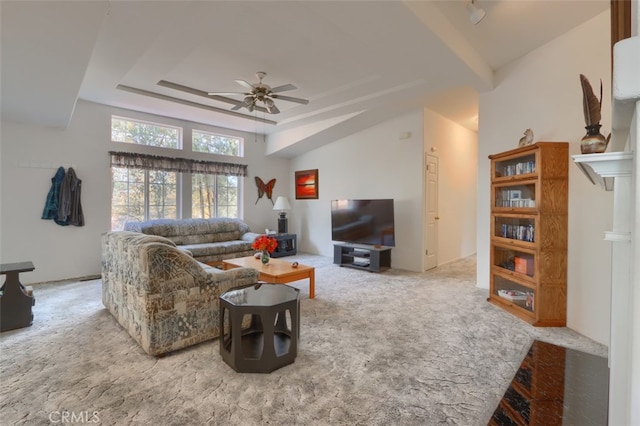 carpeted living area with a raised ceiling and ceiling fan