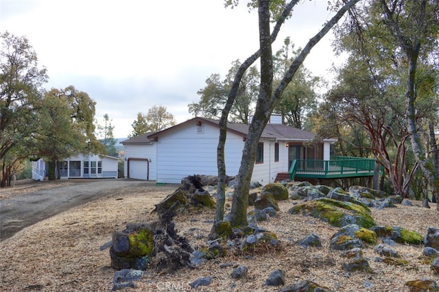 view of front of home with driveway, a garage, and a deck