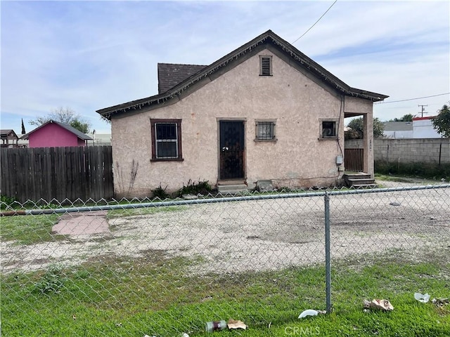 view of front of property featuring entry steps, fence, and stucco siding