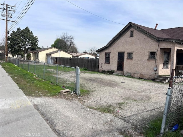 view of property exterior with entry steps, fence, and stucco siding