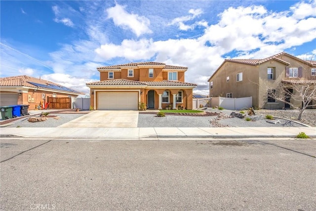 mediterranean / spanish-style house featuring a tile roof, fence, a garage, and driveway