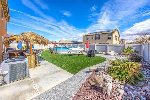 view of yard featuring a patio area, central AC unit, a fenced in pool, and a fenced backyard