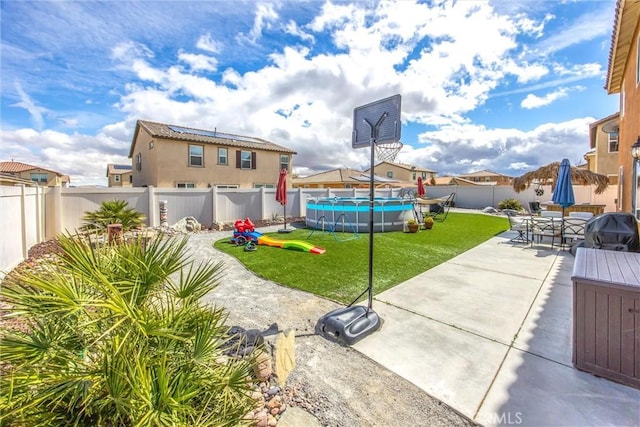 view of yard with outdoor dining area, a fenced in pool, a fenced backyard, and a patio area