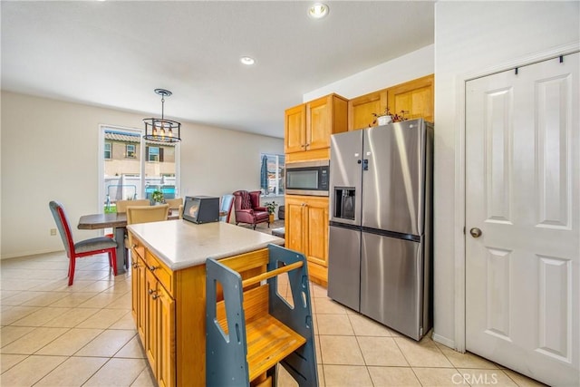 kitchen with light countertops, light tile patterned floors, a kitchen island, and stainless steel appliances