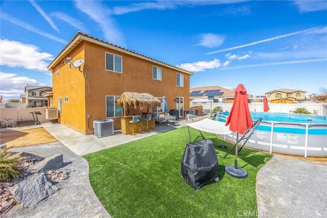 back of property with a fenced in pool, a patio, outdoor dry bar, and a fenced backyard