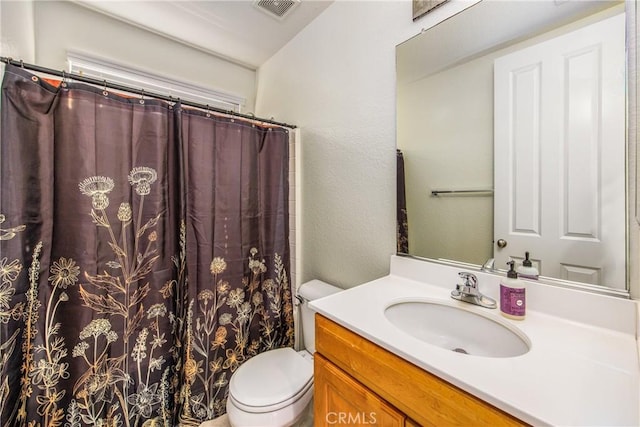 bathroom featuring visible vents, toilet, a shower with curtain, a textured wall, and vanity