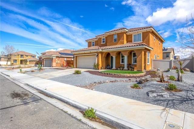 mediterranean / spanish-style home featuring fence, a tiled roof, concrete driveway, covered porch, and stucco siding