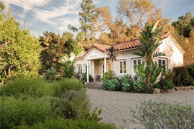 mediterranean / spanish-style home featuring a tiled roof and stucco siding