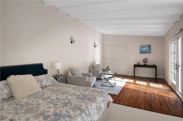 bedroom featuring a closet, wood-type flooring, vaulted ceiling with beams, and baseboards