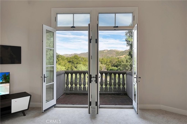 doorway featuring carpet, a mountain view, and baseboards