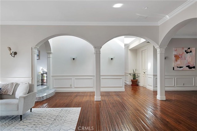 unfurnished living room featuring a decorative wall, hardwood / wood-style flooring, and crown molding