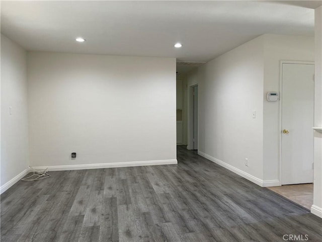 unfurnished room with baseboards, wood finished floors, and recessed lighting