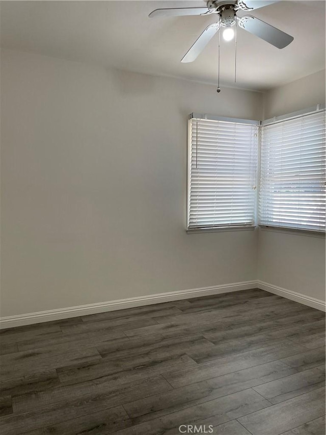 unfurnished room featuring dark wood-type flooring, baseboards, and a ceiling fan