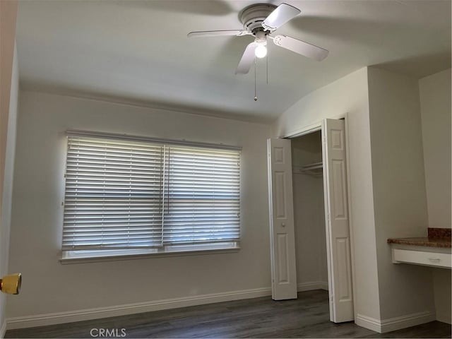 unfurnished bedroom featuring a closet, vaulted ceiling, ceiling fan, wood finished floors, and baseboards