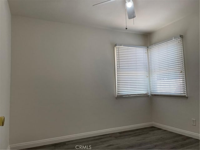 spare room with dark wood-style floors, ceiling fan, and baseboards