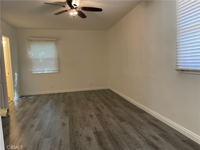 unfurnished room with dark wood-style floors, baseboards, and a ceiling fan