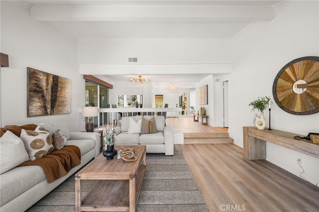 living room featuring beam ceiling, a notable chandelier, wood finished floors, and visible vents