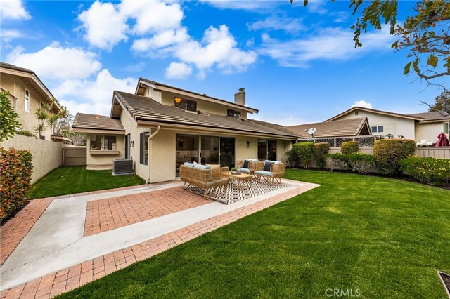 rear view of house featuring an outdoor hangout area, a chimney, a yard, a fenced backyard, and a patio area