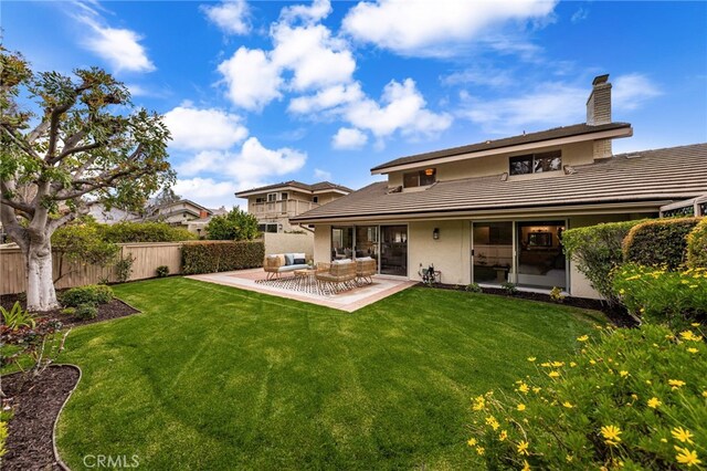 rear view of house featuring a patio area, an outdoor hangout area, a yard, and fence