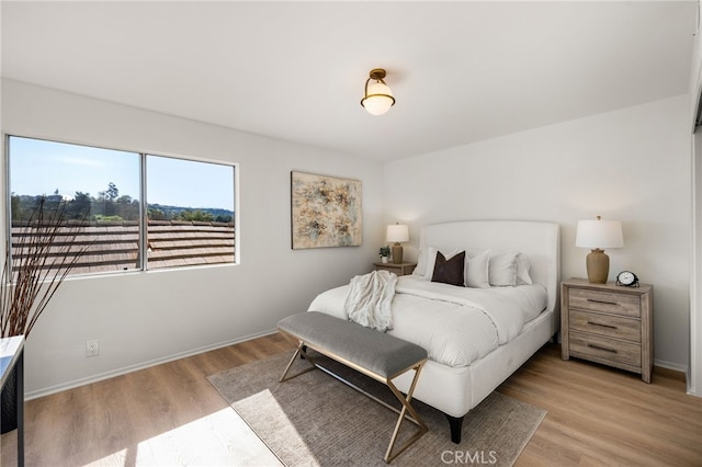 bedroom with light wood-style flooring and baseboards