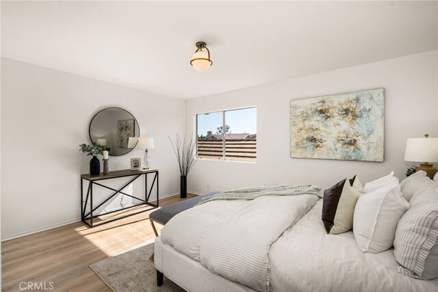 bedroom with wood finished floors and baseboards