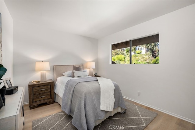 bedroom featuring baseboards and wood finished floors