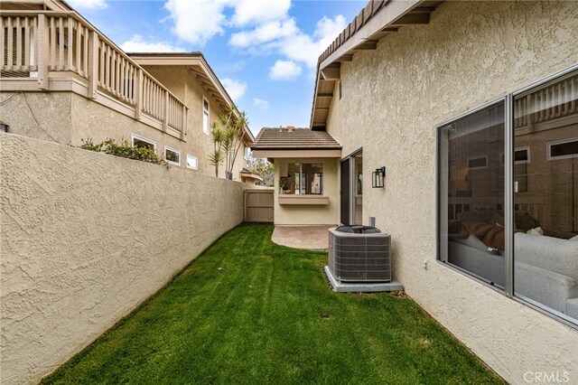 view of yard featuring central AC unit and fence