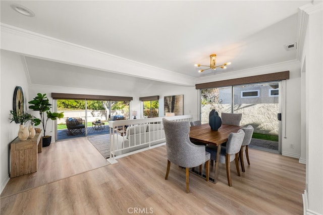 dining room with an inviting chandelier, wood finished floors, visible vents, and ornamental molding