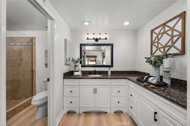 full bath with vanity, toilet, wood finished floors, and a shower stall