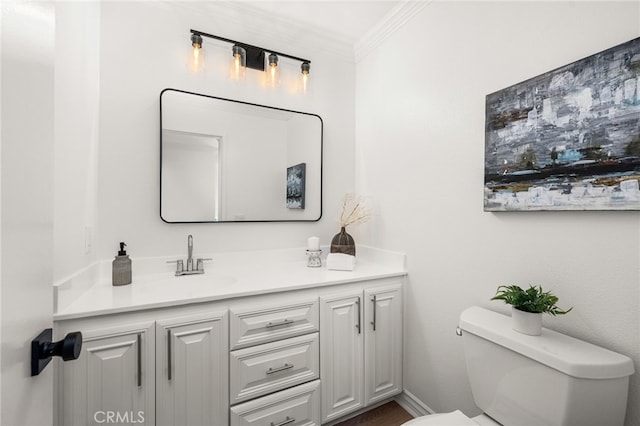 bathroom with vanity, toilet, crown molding, and baseboards