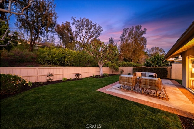 yard at dusk featuring fence private yard, outdoor lounge area, and a patio area