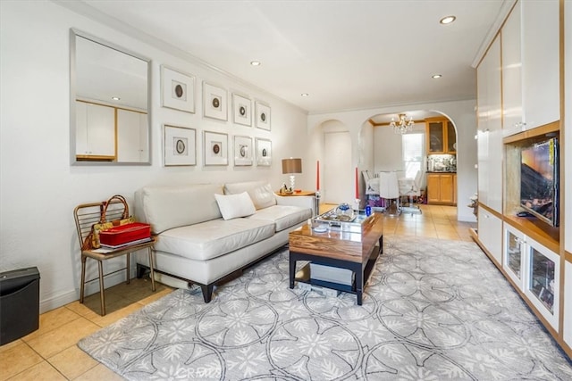 tiled living room with arched walkways, a notable chandelier, and recessed lighting