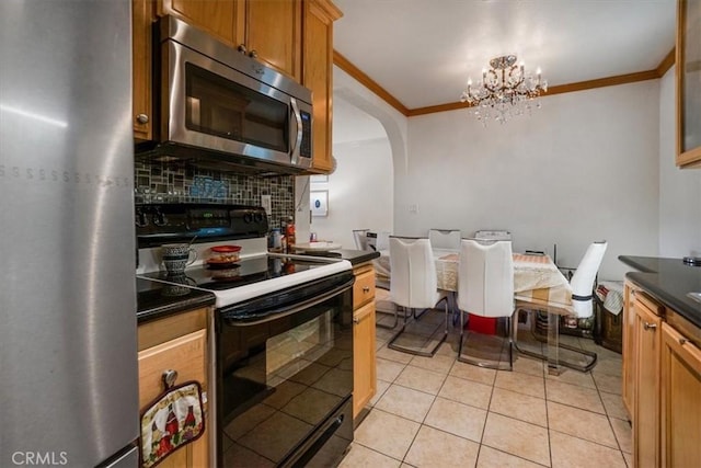 kitchen with arched walkways, decorative backsplash, dark countertops, stainless steel appliances, and crown molding