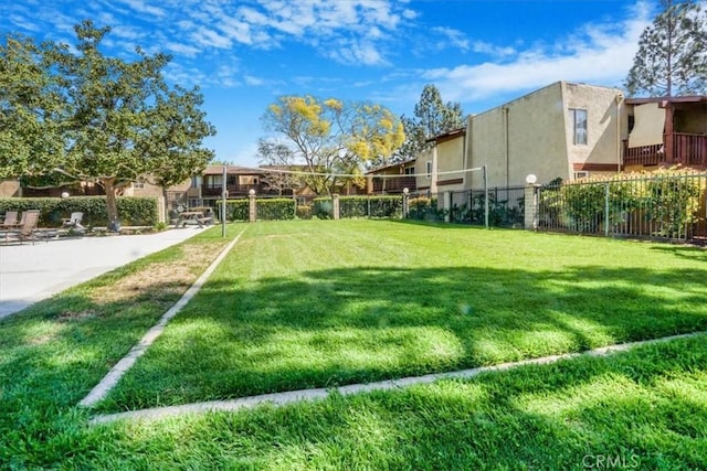 view of yard featuring fence and volleyball court