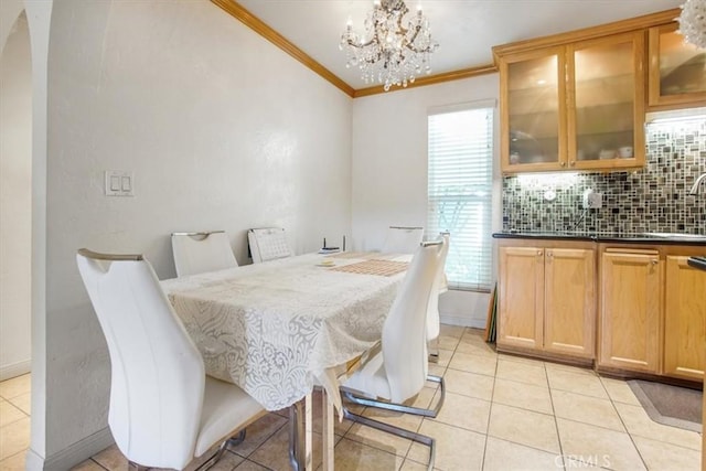 dining area featuring light tile patterned floors, crown molding, a chandelier, and a wealth of natural light