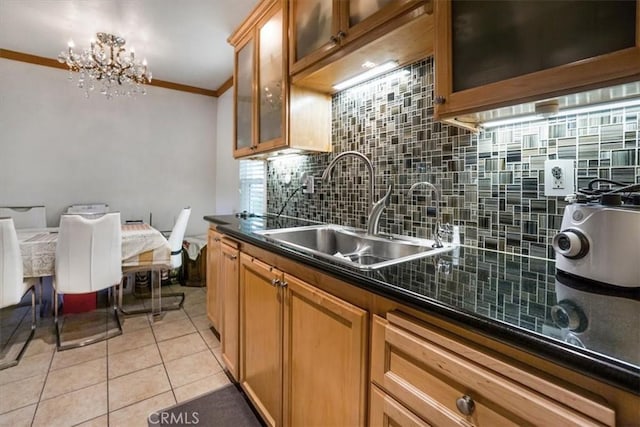 kitchen featuring dark countertops, tasteful backsplash, crown molding, and a sink