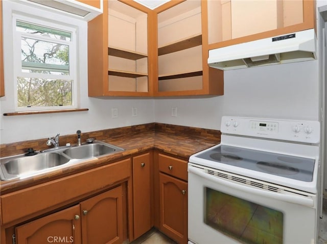 kitchen featuring white range with electric cooktop, brown cabinetry, dark countertops, under cabinet range hood, and a sink