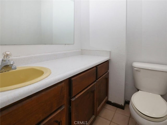 bathroom with toilet, tile patterned flooring, and vanity