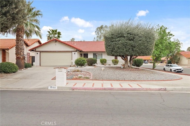 view of front of house with driveway, stucco siding, a garage, and a tiled roof