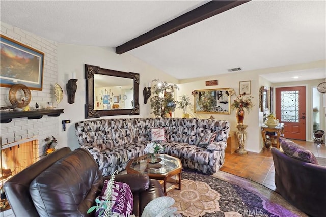 living room with vaulted ceiling with beams, a brick fireplace, and visible vents