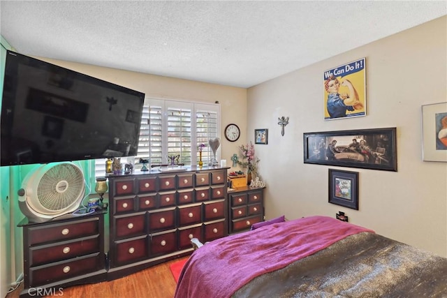 bedroom featuring a textured ceiling and wood finished floors