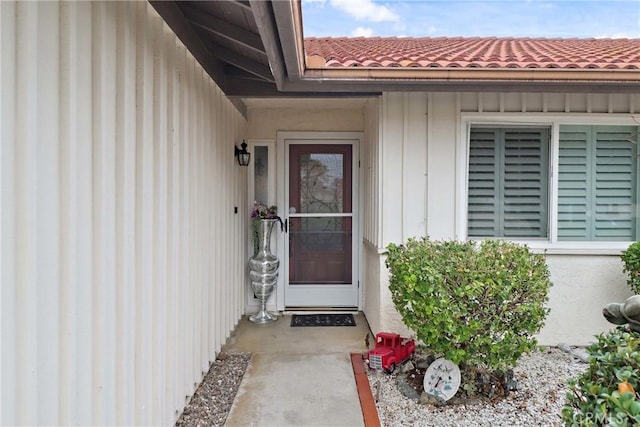 entrance to property featuring a tile roof