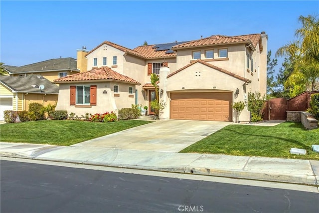 mediterranean / spanish-style home with concrete driveway, solar panels, stucco siding, a chimney, and a front yard